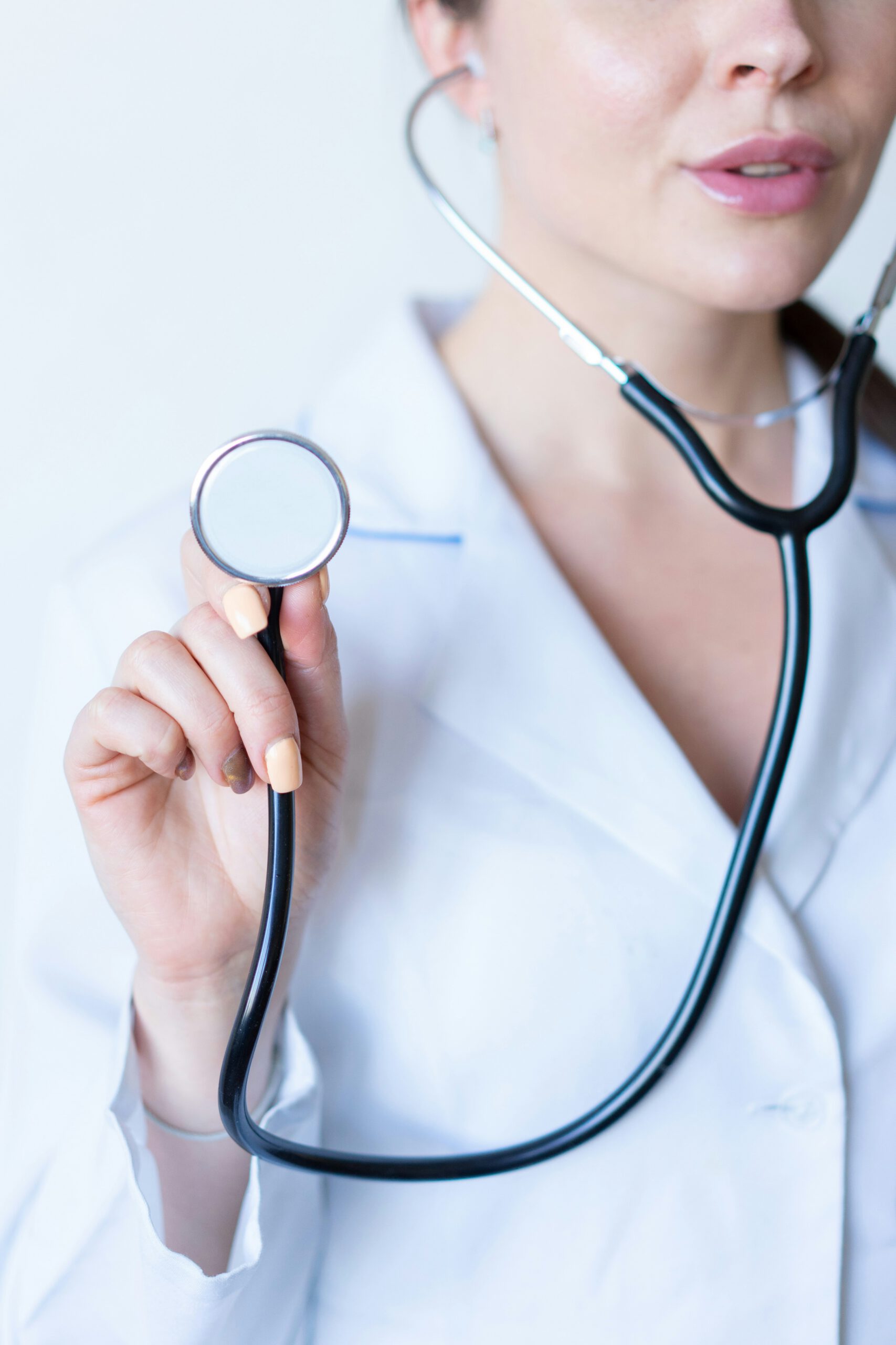Woman holding up a stethoscope.