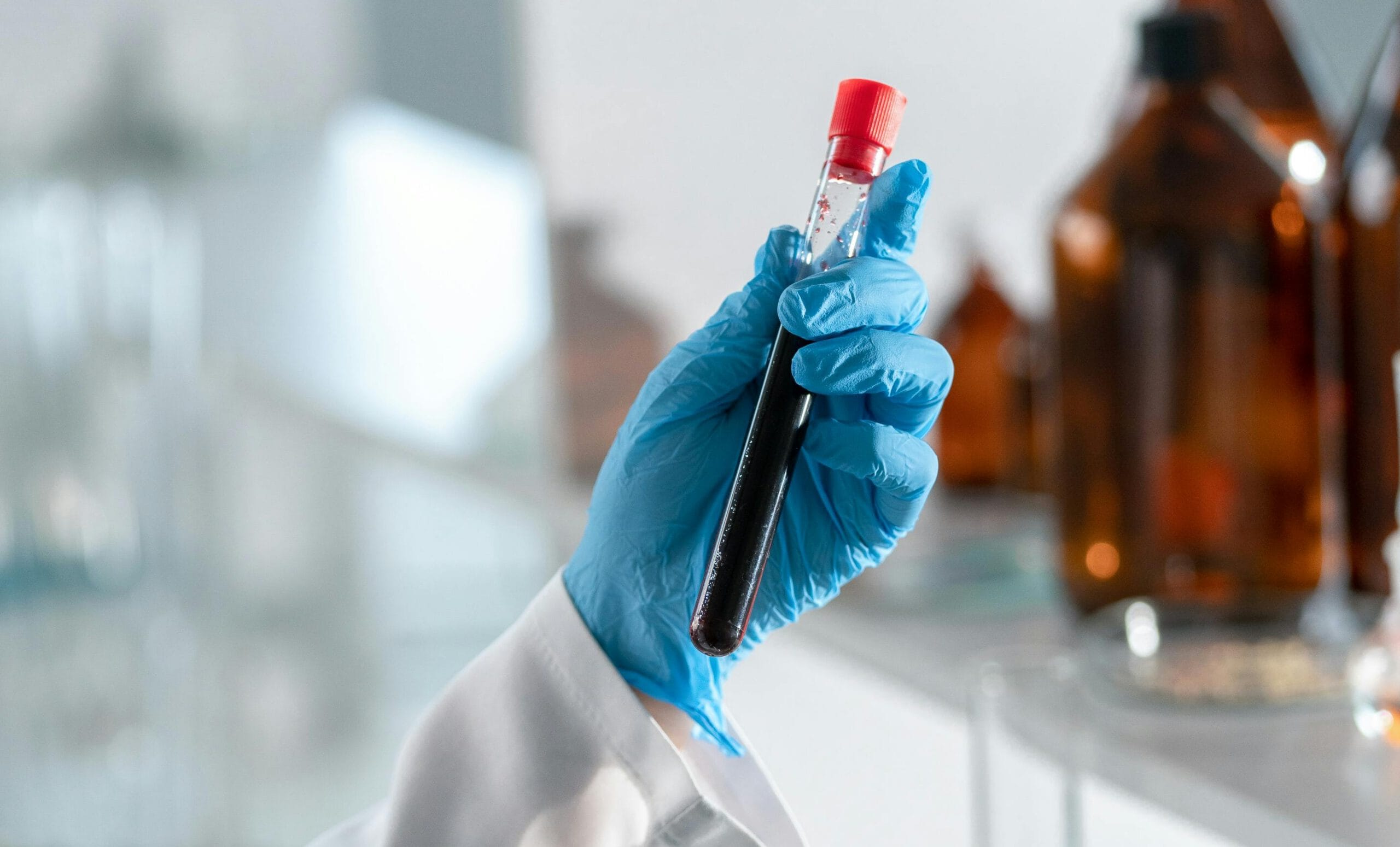 Blue glove holding a test tube.